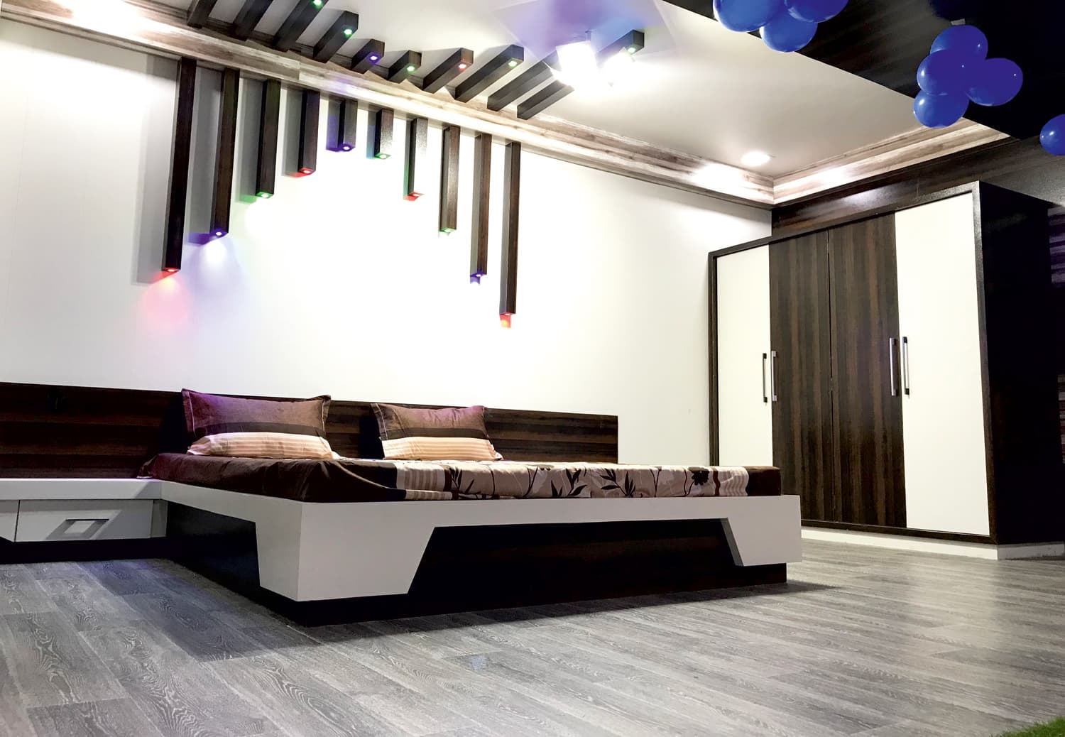 Contemporary bedroom with two-tone wardrobe and a lit slat headboard wall.