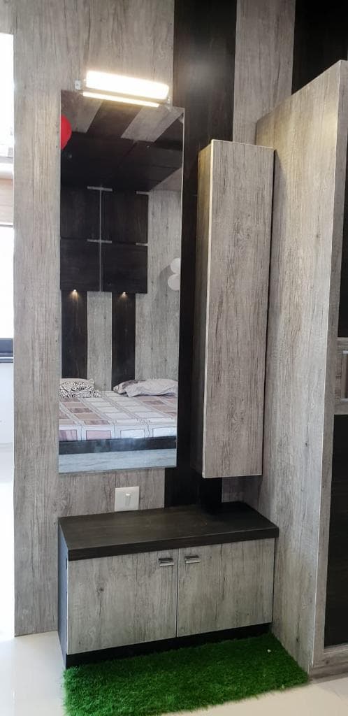 Dressing vanity with mirror, tall cabinet and wood-grain wall panels.