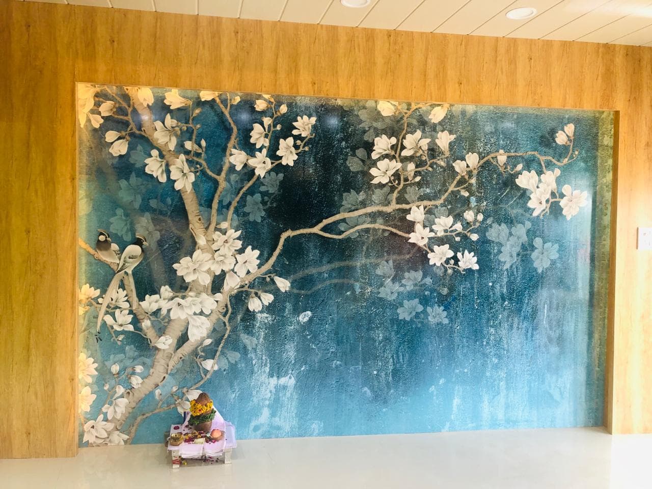 Floral wall mural framed by light wood paneling.
