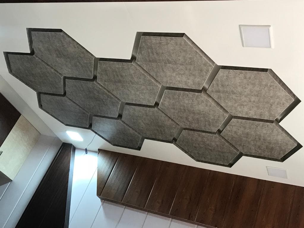 Geometric stone-textured false ceiling panels with recessed lighting.