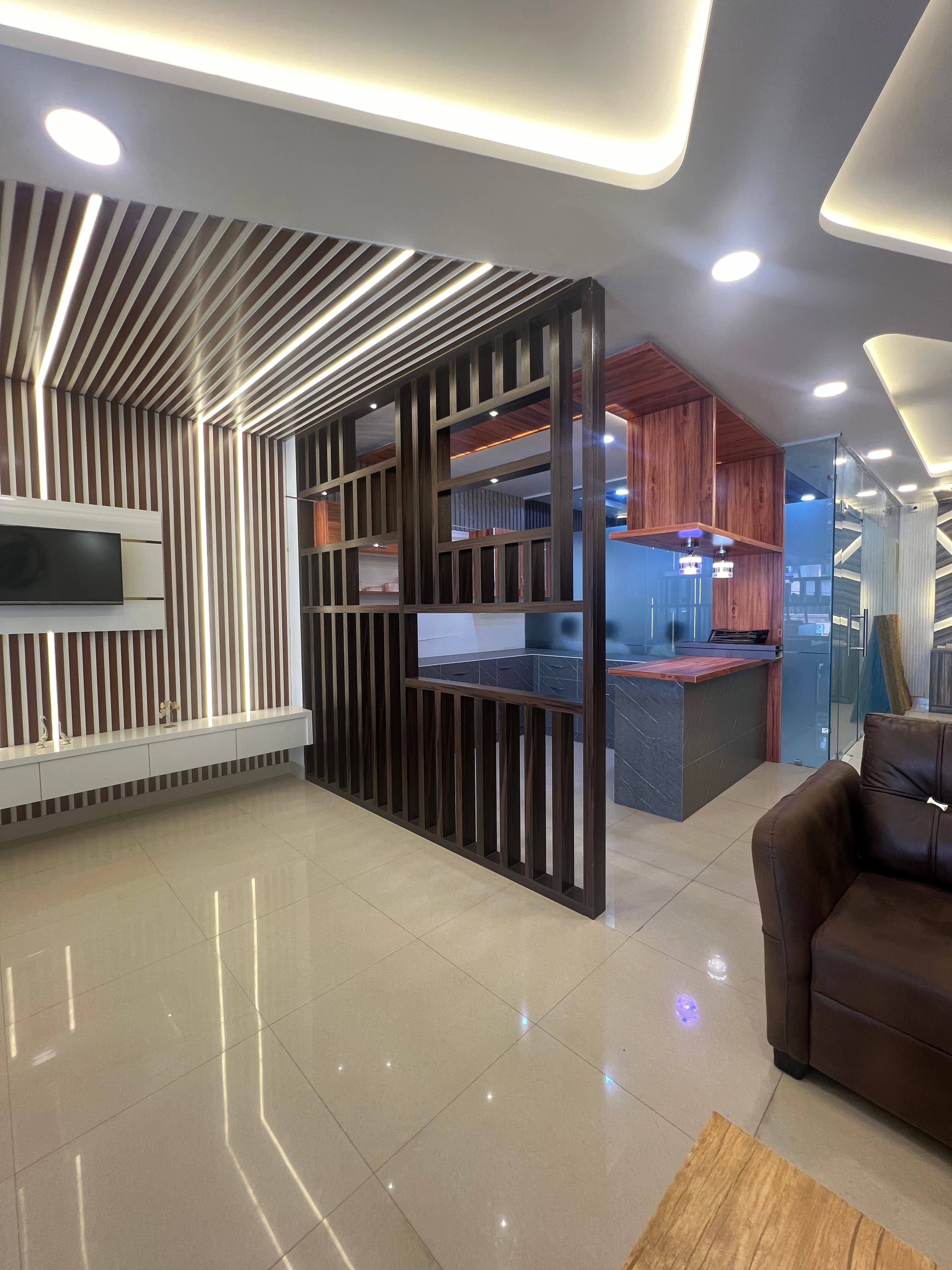 Living space with LED wood-slat media wall and open partition.