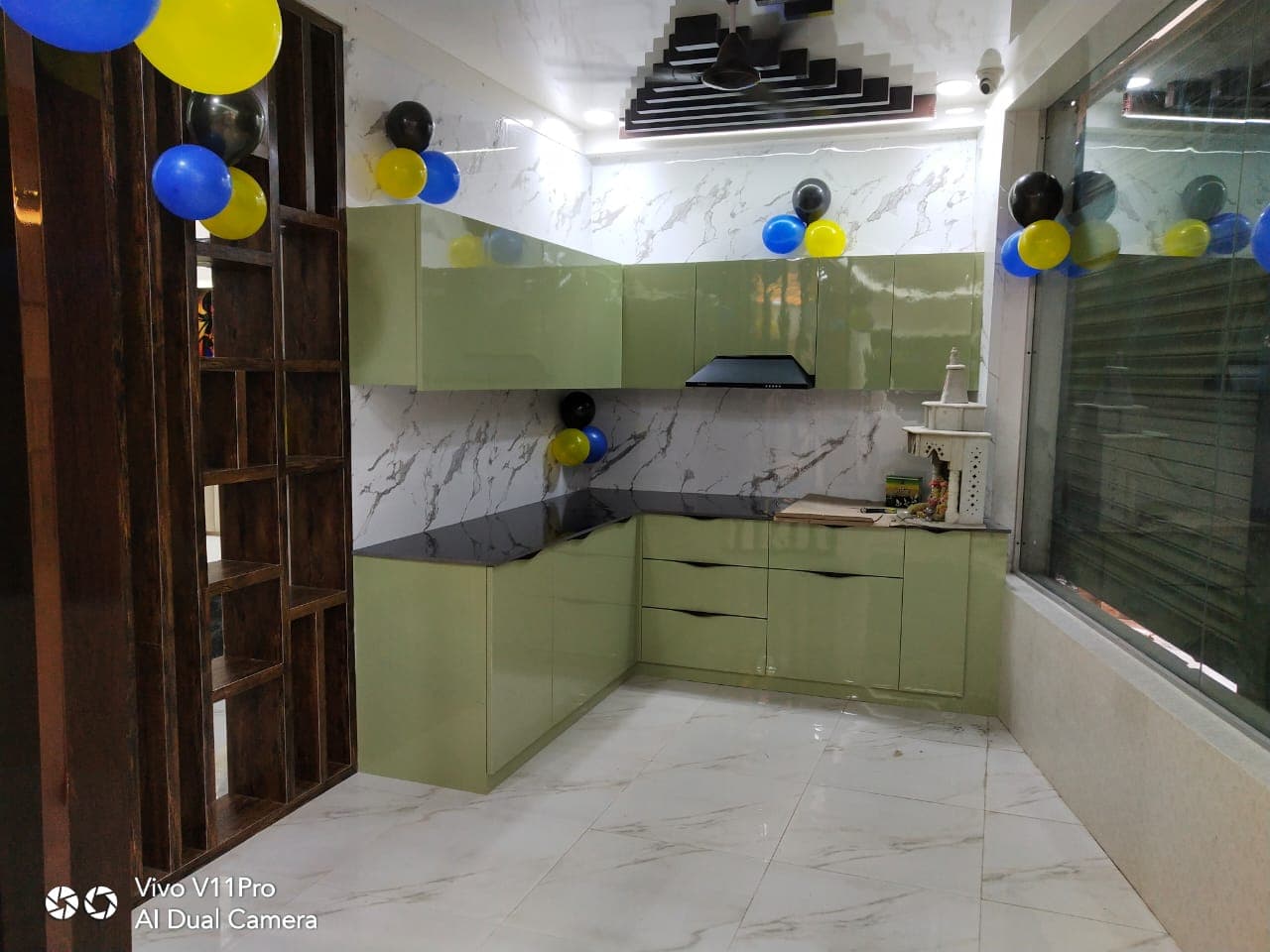 Olive-green glossy RAVYA kitchen with black countertop.