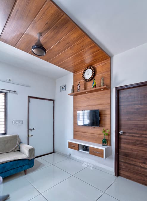 TV wall and ceiling paneling in warm wood-grain PVC.