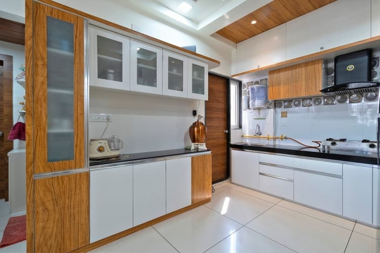 White modular PVC kitchen with wood accents and a black countertop.