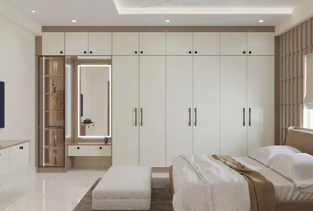 A large cream-toned wardrobe with sliding doors and integrated mirror, set in a contemporary bedroom.