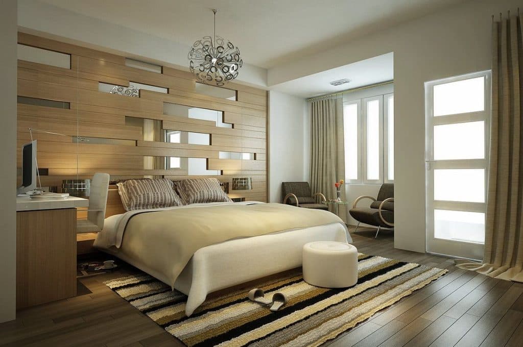 A warm contemporary bedroom with timber-framed headboard wall, integrated desk and wardrobe.