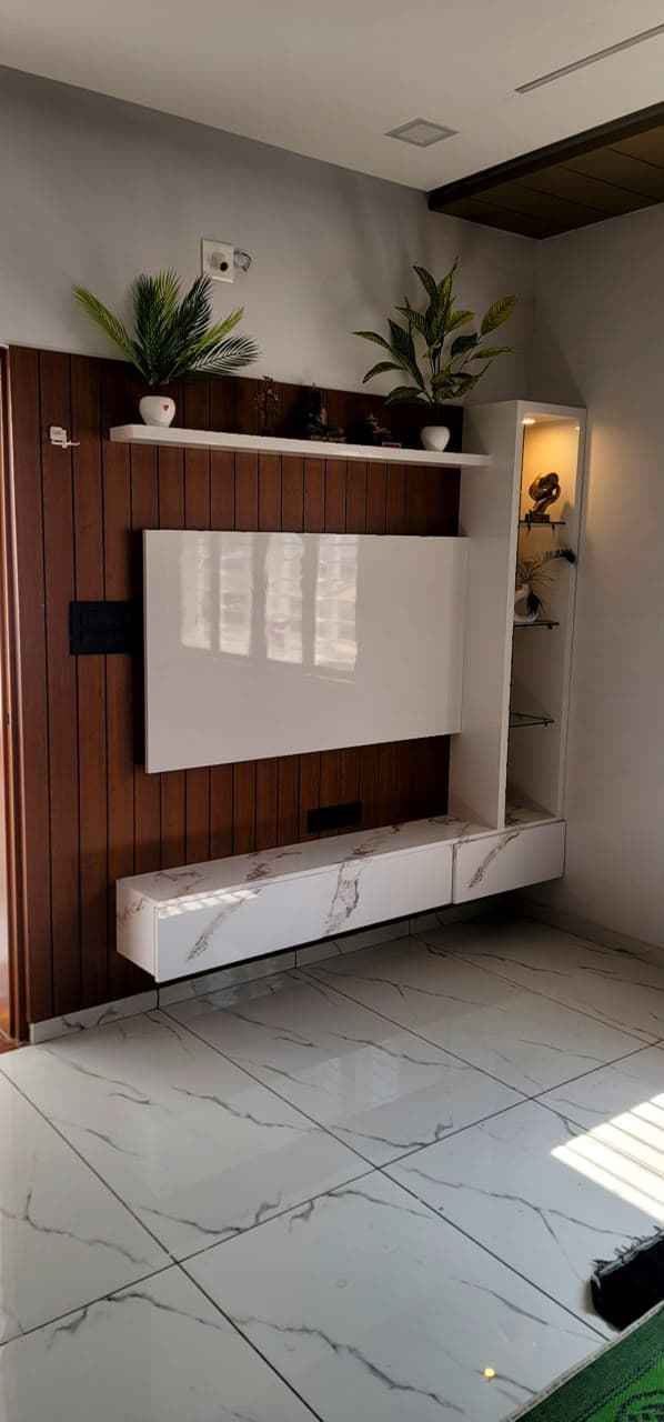 RAVYA living room media wall with concealed PVC storage and shelving.