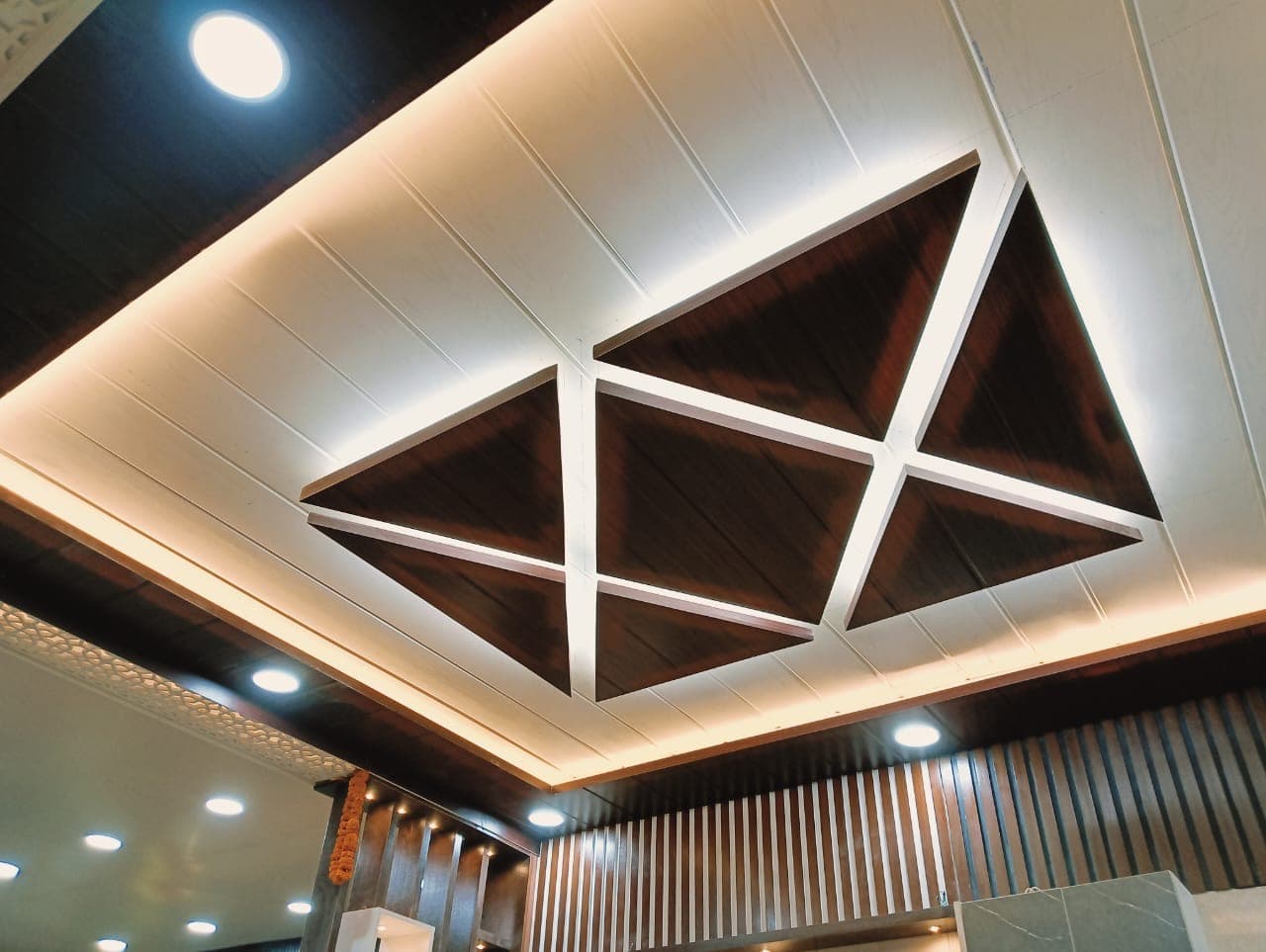 Geometric false-ceiling craftsmanship with LED backlighting.