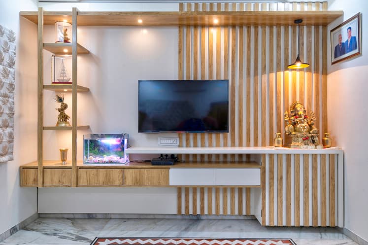 Living wall unit with media console, display shelves and an integrated pooja niche.